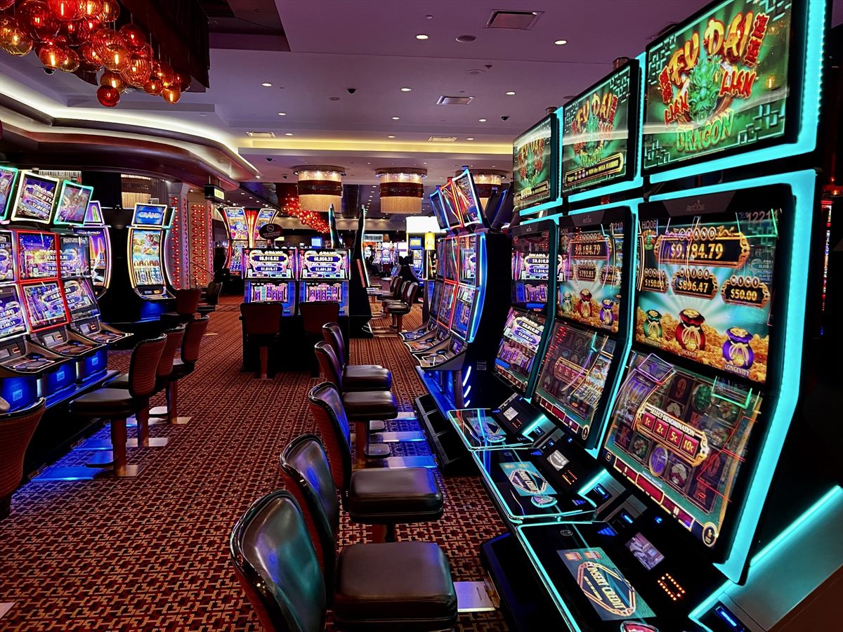 Fila de máquinas tragamonedas encendidas en el salón de un casino
